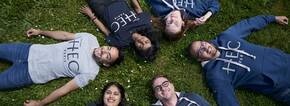 Students lying down on the grass in MBA hoodies