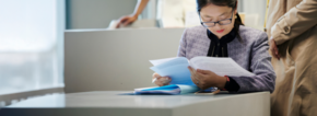 EMBA student studying a document while sitting in a classroom