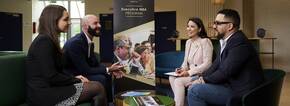 Students meeting with recruiters sitting down and smiling